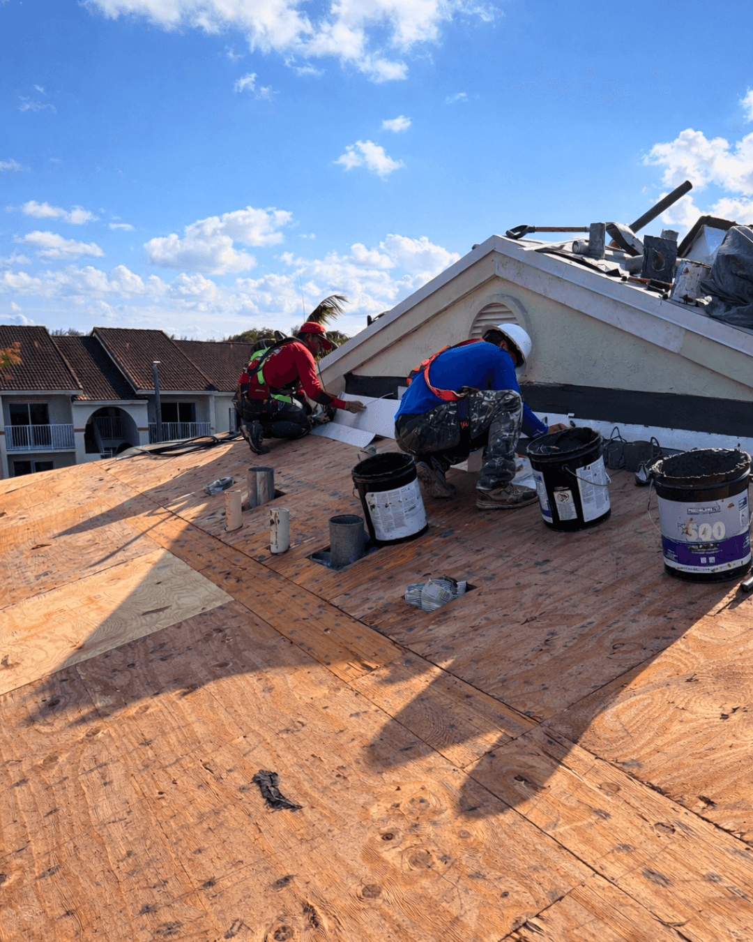 roofing workers repairing early roof damage Florida home